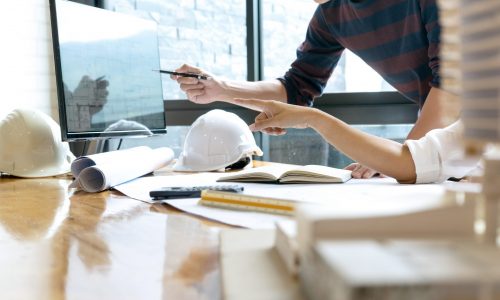 in the office  engineer or architectural project, two engineering or architecture discussing and working on blueprint with architect equipment, Construction concept.